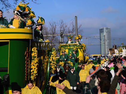 EhrenGarde im Kölner Rosenmontagszug 2023 Zu sehen ist die Gruppe der EhrenGarde im Kölner Rosenmontagszug 2023 mit Festwagen. Sie tragen grün-gelbe Uniformen. Seitlich sind die Zuschauer des Kölner Rosenmontagszuges zu sehen. Der Himmel ist blau, die Sonne scheint.