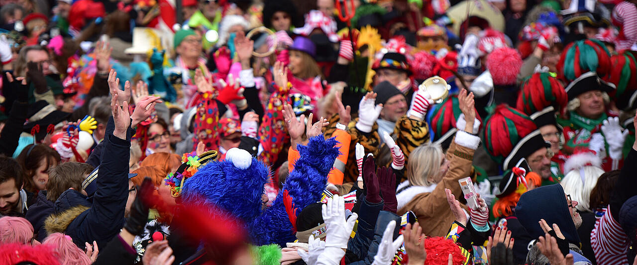 11.11. in Köln Eine bunte Menschenmenge, die Personen sind mit Kostümen verkleidet.