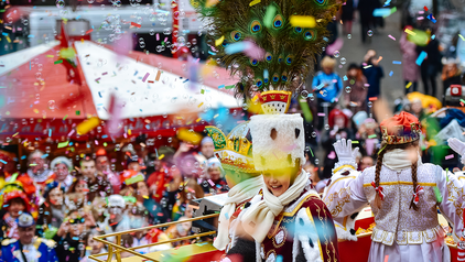 Das Kölner Kinderdreigestirn der Session 2017 ist hier auf dem Wagen im Kölner Rosenmontagszug von hinten zu sehen. Die Gesichter sind nicht zu erkennen, da viel buntes Konfetti durch die Luft fliegt. 