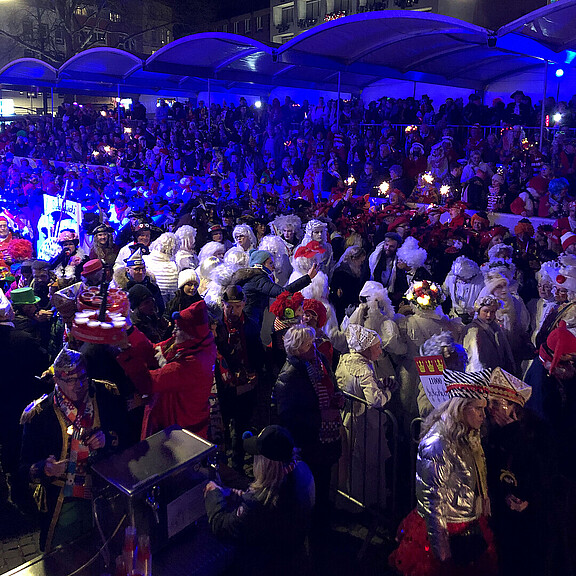 Personen auf einer Tribühne verfolgen den Zug