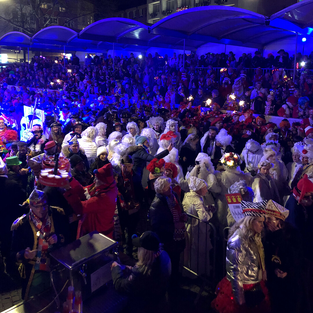 Personen auf einer Tribühne verfolgen den Zug